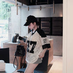 Woman in a stylish outfit with a cap and lace top in an indoor setting