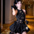 Woman in a black dress posing in a hallway