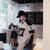 Woman in a stylish outfit with a cap and lace top in an indoor setting